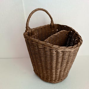 A hanging door basket in rustic style, made from woven brown fabric, is ideal for bringing a decorative touch to your doors or walls.