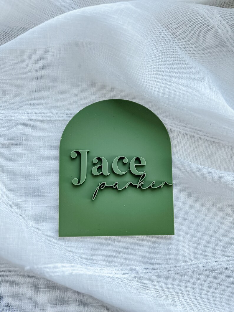 May include: A green arch-shaped sign with the name "Jace Parker" in white lettering.