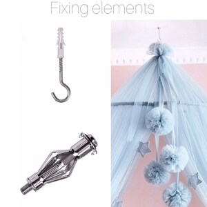 May include: Fixing elements for a canopy bed, including a white plastic anchor, a silver hook, and a silver metal toggle bolt. The canopy bed is made of light blue tulle and has white pom-poms and stars hanging from it.