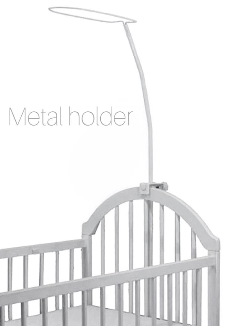 Puede incluir: Cuna de metal blanco con un soporte de metal para un dosel. El soporte est&aacute; fijado a la parte superior de la cuna y tiene un brazo curvo que se extiende sobre la cuna.