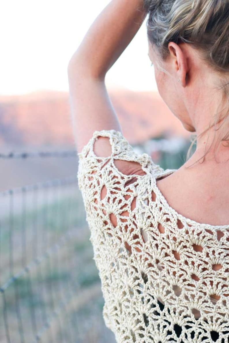 A blonde woman fixing her hair wearing a women's boho lace top.