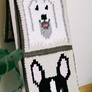 A Yorkie and Boston terrier design blanket as a gift for a dog lover draped on a wooden stair.