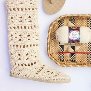 One Coachella boot, a beige slipper, and a wicker basket with a crochet hook and a yarn skein inside.