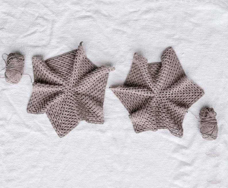Two in-progress hexagons with yarns attached to them.