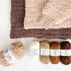 Two crochet sherpa hoodies and five yarn skeins.