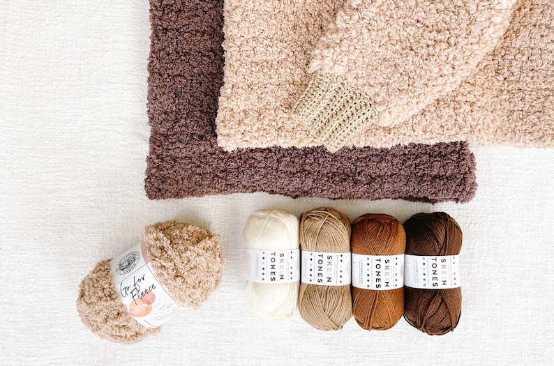 Two crochet sherpa hoodies and five yarn skeins.