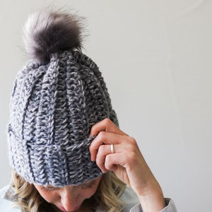 A blonde woman wearing a 1.5 hour crochet beanie with pom pom.