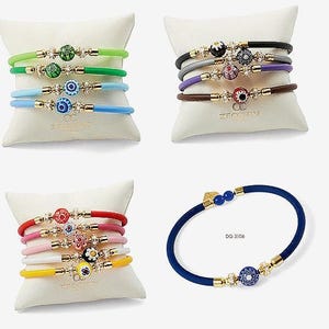 May include: Set of colourful bracelets with gold accents and various patterned beads. The bracelets are stacked on top of each other on a white surface. The text "Zircus" is visible on the surface.