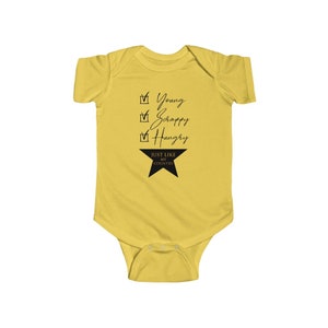 Pode incluir: Macac&atilde;o de beb&ecirc; amarelo com texto preto que diz "Young, Scrappy, Hungry, Just Like My Country" com uma estrela preta.
