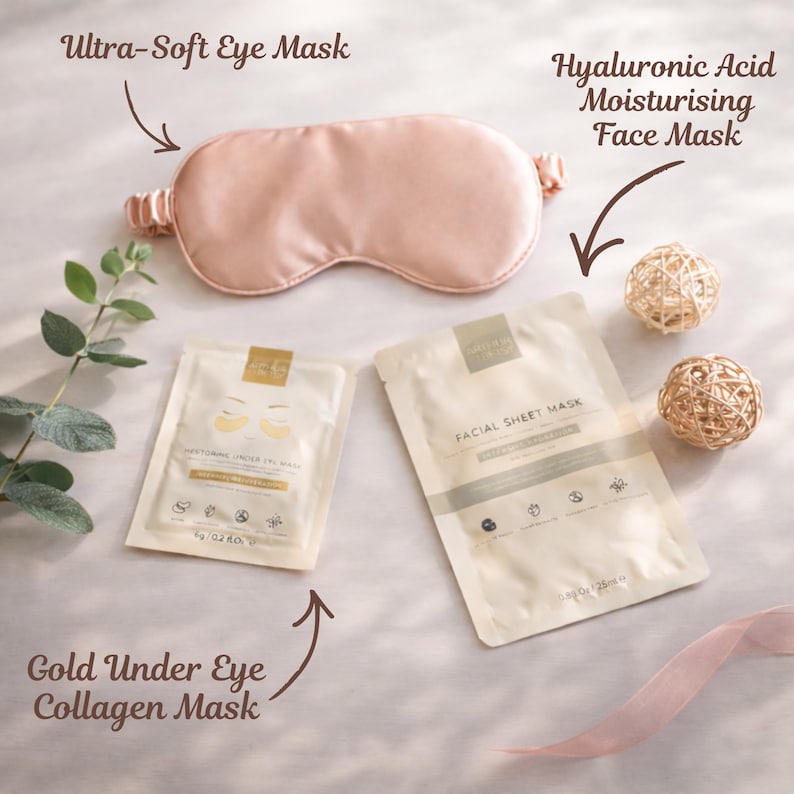 A peach-coloured eye mask, two facial sheet masks, and a gold under-eye collagen mask are displayed. The text on the packaging reads "Ultra-Soft Eye Mask", "Hyaluronic Acid Moisturising Face Mask", and "Gold Under Eye Collagen Mask". Two decorative spheres and a ribbon complete the arrangement.