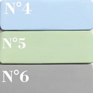 May include: Three painted wooden blocks stacked on top of each other. The top block is light blue with the text "N&deg;4" in white. The middle block is light green with the text "N&deg;5" in white. The bottom block is gray with the text "N&deg;6" in white.