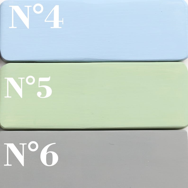 May include: Three painted wooden blocks stacked on top of each other. The top block is light blue with the text "N&deg;4" in white. The middle block is light green with the text "N&deg;5" in white. The bottom block is gray with the text "N&deg;6" in white.