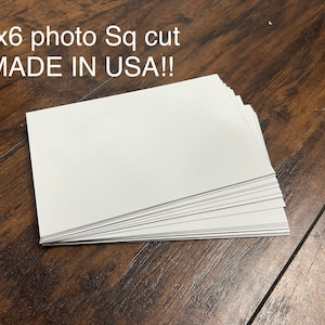 May include: A stack of white 4x6 inch square cut photo paper. The paper is made in the USA.