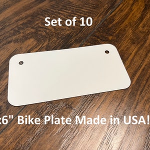 May include: Set of 10 blank white 3" x 6" bike plates made in the USA. Each plate has two holes for hanging.