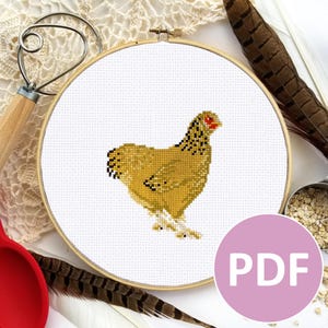 May include: A cross-stitch pattern of a yellow chicken with black markings and red eyes. The pattern is displayed in a round embroidery hoop. The image includes the word "PDF" in a pink circle.