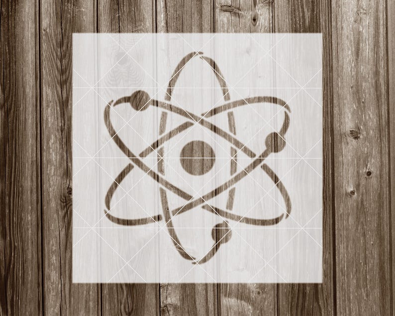 May include: A white stencil of an atom with a nucleus and orbiting electrons. The stencil is on a wood background.