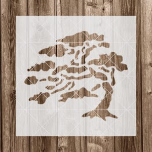 May include: A stencil of a stylized tree with a thick trunk and branches that spread out to the sides. The tree is outlined in white against a white background.