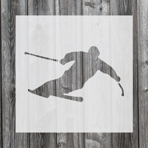 May include: A white stencil of a skier in a downhill skiing pose with ski poles.