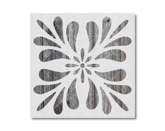 Peut inclure: Un pochoir carré présentant un motif floral symétrique avec des pétales en forme de goutte d'eau rayonnant à partir d'un point central circulaire. Le motif est découpé sur un fond à texture de grain de bois gris foncé.
