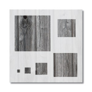 May include: A square wooden panel with a white border features several inset squares of weathered gray wood grain. The wood grain varies in size and texture, creating a visually interesting contrast. The panel is set against a white background.