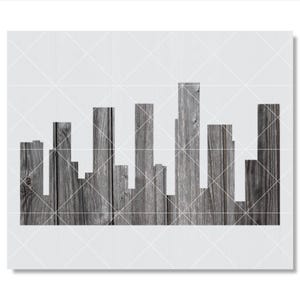 May include: A wall art piece featuring a stylized city skyline silhouette constructed from vertical dark gray wooden planks with visible grain patterns, set against a plain white background with a faint grid overlay pattern.