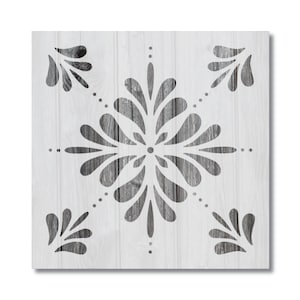 May include: A white wooden square with a gray cutout design of a stylized snowflake. The snowflake has a central circle with four petals extending out from the center. The petals have a series of smaller petals extending out from them.