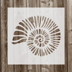 May include: White stencil of a nautilus shell with a spiral pattern. The stencil is on a wood background.