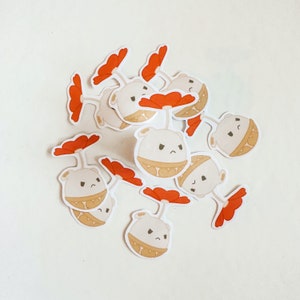 Puede incluir: Un conjunto de 10 pegatinas con adorables personajes de dibujos animados con acentos de flores rojas. Los personajes son blancos con ojos y bocas negros. Las pegatinas son perfectas para agregar un toque de fantasía a las computadoras portátiles, las botellas de agua o los diarios.