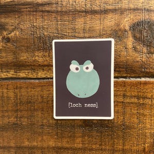 May include: A dark purple sticker with a green cartoon monster with white eyes and the text "[loch ness]" in white.