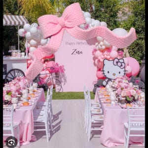 May include: A pink party scene with tables set for a celebration. A large pink bow and balloons decorate the background. The text "Happy Birthday Zara" is visible. A Hello Kitty figure is also present.