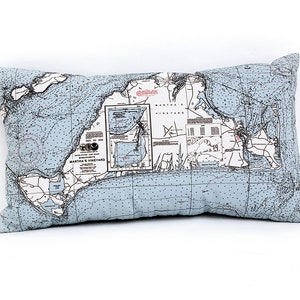 May include: A light blue throw pillow with a nautical map of Martha's Vineyard printed on the front. The map is in black and white with blue accents.