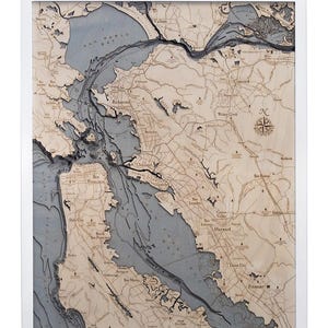 May include: A detailed wooden map of the San Francisco Bay Area, with the water bodies colored in blue and the land areas in a light brown color. The map includes the names of various cities and towns, including San Francisco, Oakland, Richmond, Hayward, Fremont, and San Mateo.