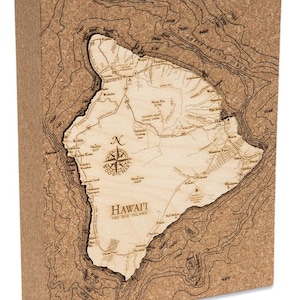 May include: A corkboard map of the island of Hawaii, showing the major cities and towns, as well as the island's topography. The map is surrounded by a brown corkboard frame. The text "HAWAI'I THE BIG ISLAND" is printed in the center of the map.