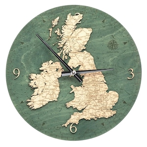 May include: A round wooden wall clock featuring a map of the British Isles. The clock face is a teal green color, with the map in a lighter wood tone. The clock hands are black, and the numbers are gold. The clock has the text "WOOD CHIC" and "DEPTHS IN METERS".