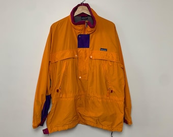 May include: A bright orange jacket with purple and red accents. The jacket has a zip closure and a drawstring at the waist.
