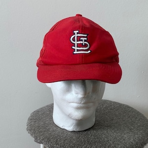 Könnte beinhalten: Rote Baseballkappe mit weißem Netzrücken und einem weißen gestickten St. Louis Cardinals Logo.