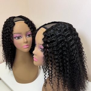 Peut inclure: Deux têtes de mannequin avec des perruques bouclées foncées. Les perruques ont une conception en forme de U, révélant le cuir chevelu. Les mannequins ont la peau bronzée, des lèvres roses et des fards à paupières roses. Le fond est un mur uni de couleur claire.