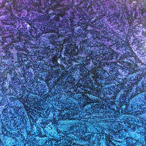 May include: Abstract background with a gradient of colors. The image transitions from a deep purple at the top to a vibrant blue at the bottom. The surface has a textured, glittery appearance, creating a sparkling effect.