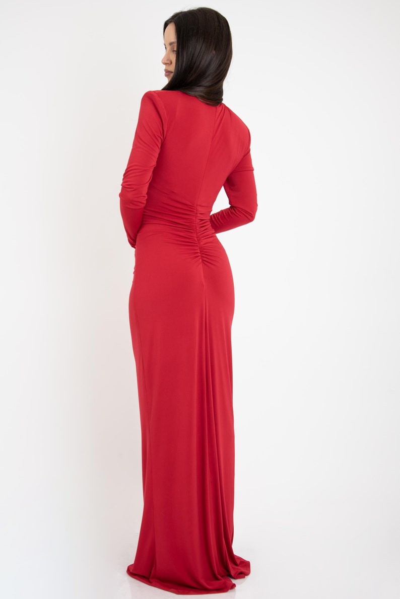 May include: A long-sleeved, red maxi dress with a fitted bodice and a gathered back.
