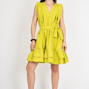 Peut inclure: Une robe sans manches vert citron avec un d&eacute;collet&eacute; en V, une ceinture &agrave; nouer &agrave; la taille et un ourlet &agrave; volants. La robe est faite d'un tissu l&eacute;ger et est parfaite pour l'&eacute;t&eacute;.