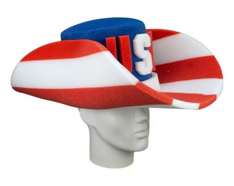 Puede incluir: Un sombrero de espuma con forma de tricornio con rayas rojas y blancas y una parte superior azul. El sombrero tiene las letras "US" en la parte delantera.