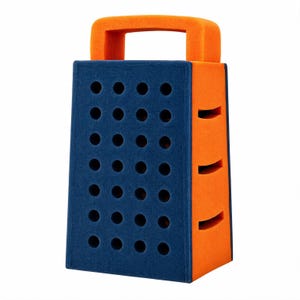May include: A foam toy grater featuring a dark blue front panel with a grid of circular cutouts and orange side panels with horizontal slit cutouts. The top of the object includes an integrated orange handle, creating a structured shape.