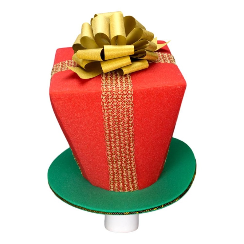Peut inclure: Un chapeau de No&euml;l fantaisie en forme de bo&icirc;te cadeau. Le chapeau pr&eacute;sente une bo&icirc;te rouge vif avec un ruban et un n&oelig;ud dor&eacute;s. Il repose sur un bord vert et une base blanche, ce qui en fait un accessoire de f&ecirc;te amusant.