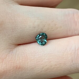May include: A heart-shaped green gemstone with a faceted cut.