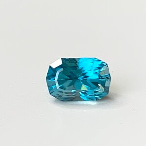 Puede incluir: Una piedra preciosa azul con forma de oct&oacute;gono rectangular.