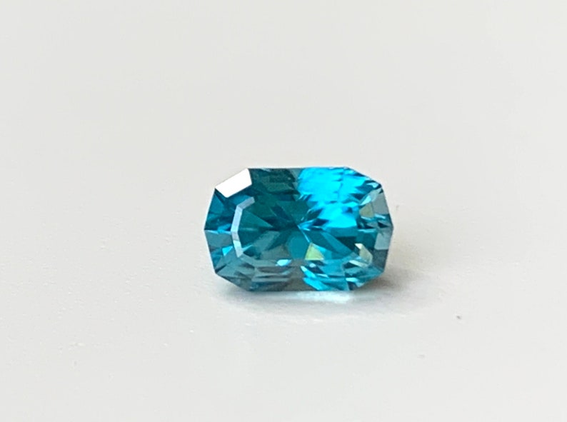 Puede incluir: Una piedra preciosa azul con forma de oct&oacute;gono rectangular.