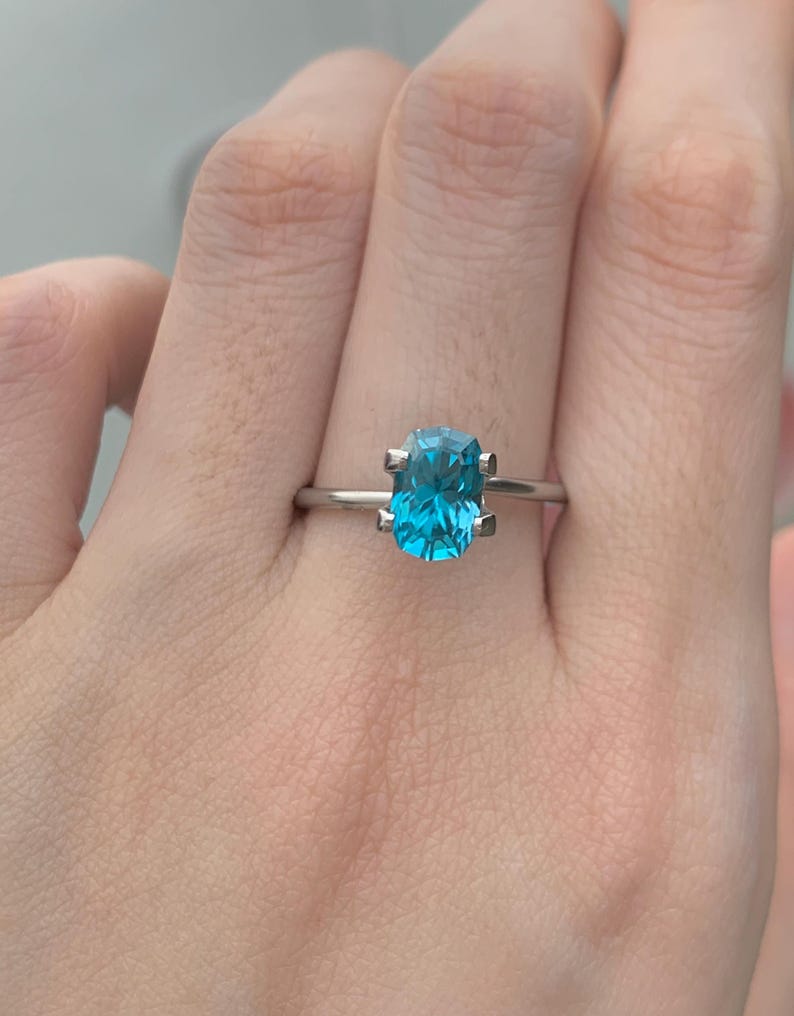 Puede incluir: Un anillo de plata con una piedra preciosa azul de talla coj&iacute;n.