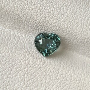 May include: A heart-shaped gemstone with a light blue-green color.