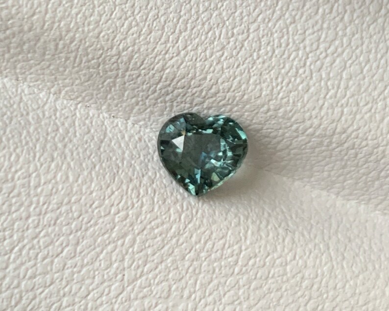 May include: A heart-shaped gemstone with a light blue-green color.