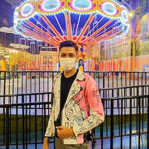 Model wearing a painted leather jacket designed by Lil Peep in front of the carousel
